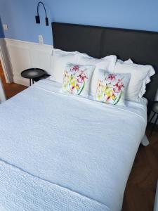 a white bed with two pillows on top of it at Tres Bel Appartement Vieux Port De Bastia in Bastia