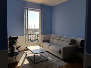 a living room with a couch and a window at Tres Bel Appartement Vieux Port De Bastia in Bastia