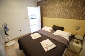 a bedroom with a bed with two towels on it at Apartamento Justina in Cullera +17 photos