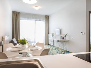 une salle à manger blanche avec une table et des chaises dans l'établissement VacationClub - Baltic Park Molo Apartment D110, à Świnoujście