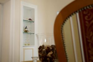 ナルドにあるPalazzo Volta Boutique Luxury B&Bのテーブル、鏡、棚付きの部屋