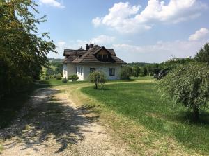eine unbefestigte Straße, die zu einem weißen Haus führt in der Unterkunft Villa Okale in Kazimierz Dolny