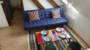 オーにあるAppartement centre village vue mer - Relais Fleuriのリビングルーム(青いソファ、テーブル付)