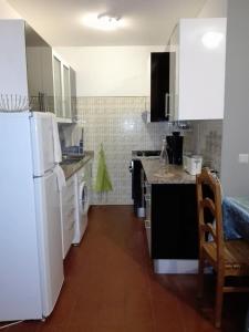 a kitchen with white appliances and a white refrigerator at Arrifana Summer Flat in Aljezur