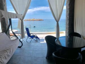 a view of the ocean from a room with a table and chairs at Apartments Lungo Mare in Sveti Stefan