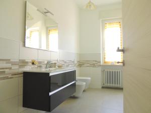 a bathroom with a sink and a toilet and a mirror at BNB Airone in Sommariva Perno
