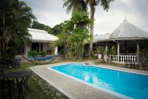 a house with a swimming pool and a gazebo at Auberge Chez Plume in Anse Boileau