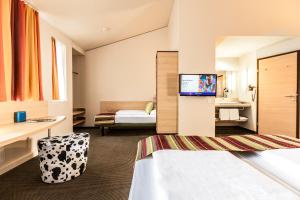 una camera d'albergo con un letto e una TV di TUI BLUE Schladming a Schladming