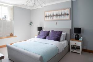 a bedroom with a large bed with purple pillows at Boutique house central Wells in Wells