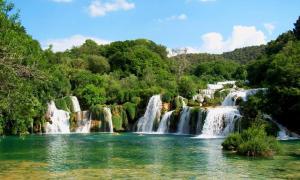 a group of waterfalls in the middle of a river at Sobe Braica in Drniš