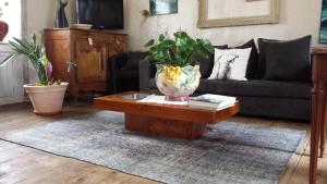uma sala de estar com um vaso numa mesa de centro em La Tocade Del Arte - Dinan em Lanvallay