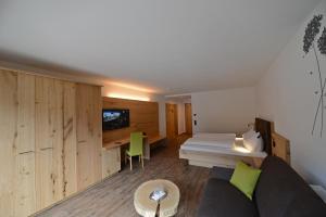 a room with a couch and a bed and a table at Naturhotel Haller in Racines