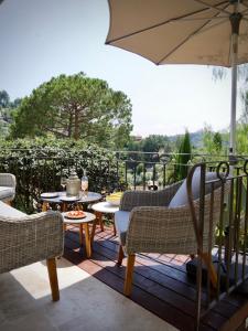 een patio met stoelen en tafels en een parasol bij L'Atelier in Vence +20 foto's