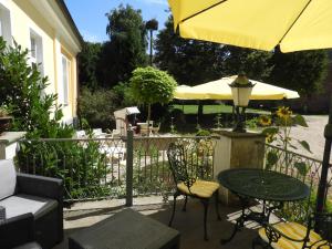 een patio met een tafel en een gele parasol bij Landhotel Gut Zarrentin in Gransebieth
