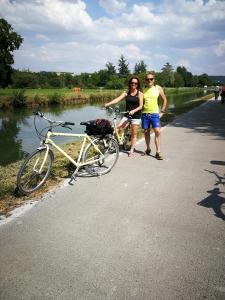 dos personas de pie junto a una bicicleta en una carretera en Villa Rose en Escolives-Sainte-Camille