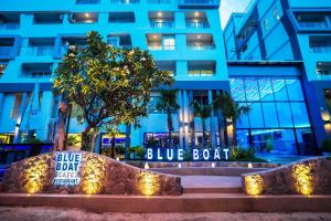 a blue building with a blue boat sign in front of it at Blue Boat Design Hotel in North Pattaya