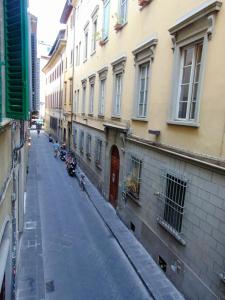 an empty street in a city with buildings and motorcycles at Gessi Charming Apartments in Florence