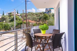 a table and chairs on a balcony with a plant at Villa Tasos-Potos Thassos in Potos