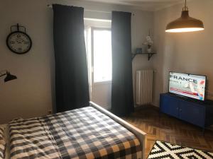 Schlafzimmer mit einem Bett, einer Uhr und einem TV in der Unterkunft Loft Studio in Giżycko