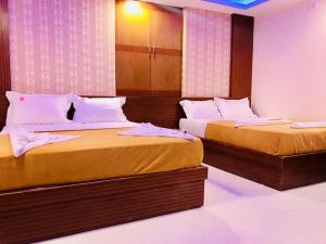 dwa łóżka w pokoju hotelowym z dwoma łóżkami w obiekcie Hotel Grand Suites w mieście Bengaluru