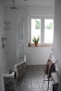 baño con ducha y suelo de baldosa. en Apartment Rheingold en Bayreuth