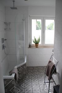 baño con ducha y suelo de baldosa. en Apartment Rheingold, en Bayreuth
