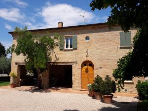 - un grand bâtiment en briques avec une porte et une fenêtre dans l'établissement La Corte, à San Giovanni in Marignano