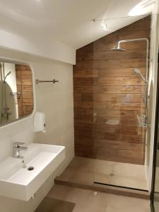 a bathroom with a sink and a glass shower at Mihaylova kushta in Lyubosh