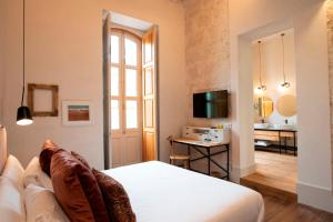 Habitación de hotel con cama y TV en VEINTIUNO Emblematic Hotels - Adults Only en Las Palmas de Gran Canaria