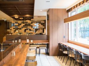 a dining room with wooden tables and chairs at Super Hotel Shinyokohama in Yokohama