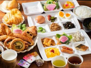 a table with many plates of food on it at Super Hotel Shinyokohama in Yokohama