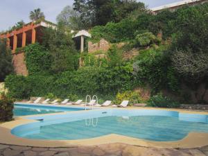 una piscina con tumbonas y un edificio en Auberge des Cascades Imouzzer - Paradise Valley en Imouzzer des Ida Ou Tanane