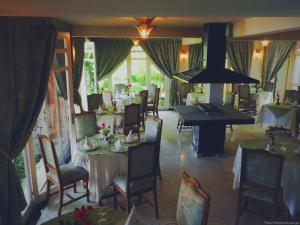 a dining room with tables and a grand piano at Auberge des Cascades Imouzzer - Paradise Valley in Imouzzer des Ida Ou Tanane