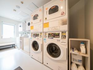 a laundry room with three washer and dryer machines at Super Hotel Shinyokohama in Yokohama