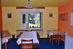 comedor con mesa, sillas y ventana en Privat Pohoda, en Paseky nad Jizerou