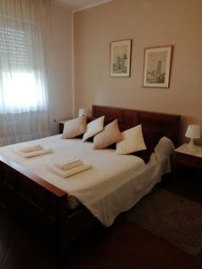 - une chambre dotée d'un grand lit avec des draps et des oreillers blancs dans l'établissement Casa degli angeli, à Lucques