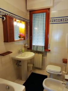 La salle de bains est pourvue d'un lavabo, de toilettes et d'une fenêtre. dans l'établissement Casa degli angeli, à Lucques