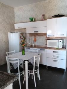 a kitchen with a table with chairs and a refrigerator at Cantinho Aconchegante in Brotas