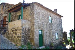 an old stone building with a green door at Castelo Cottages II in Monsanto
