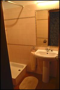 a bathroom with a sink and a toilet and a mirror at Castelo Cottages II in Monsanto