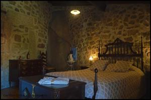 a bedroom with a bed and a table in it at Castelo Cottages II in Monsanto