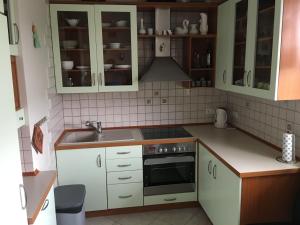 małą kuchnię z białymi szafkami i zlewem w obiekcie Apartament Park w mieście Słupsk
