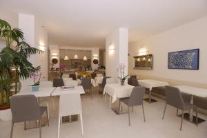 a dining room with white tables and chairs at Hotel Eldorado, Depandance & Apartments in Grado