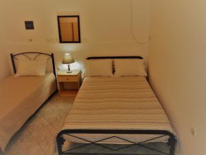 カラマタにあるElena's House Kalamata cityのベッドルーム1室(ベッド2台、ランプ付きのナイトスタンド付)