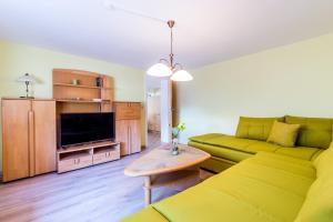 a living room with a yellow couch and a table at Ferienwohnung Andrea in Pohl