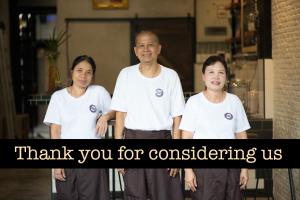 Un groupe de trois personnes se tenant côte à côte dans l'établissement Sawatdee Guesthouse the Original, à Bangkok