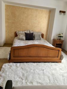 a bedroom with a large wooden bed with pillows at Domeniul Horj Apartament Moisei in Moisei