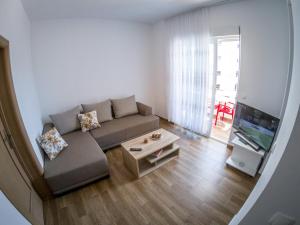 a living room with a couch and a flat screen tv at Queen Apartments & Rooms in Dobra Voda