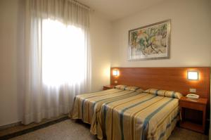 a bedroom with a bed and a large window at Hotel Moderno in Pisa