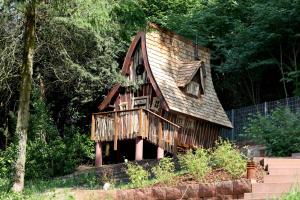 a tree house with a porch and a deck at Hexenhäuschen am Waldrand in Annweiler am Trifels